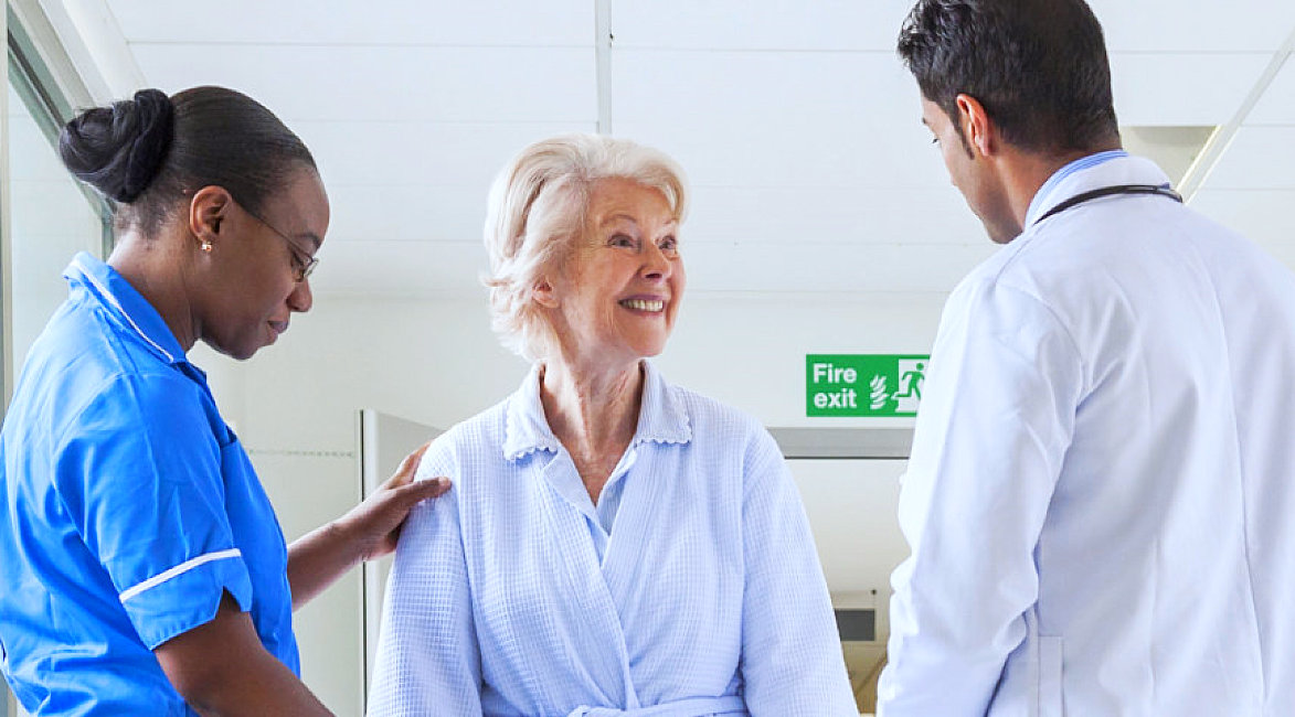 medical staffs and old woman having a conversation