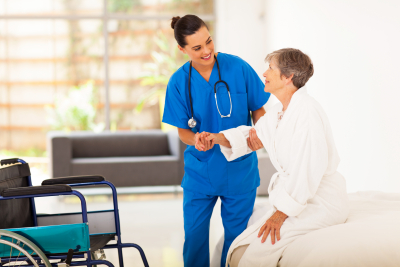 nurse helping senior in getting up